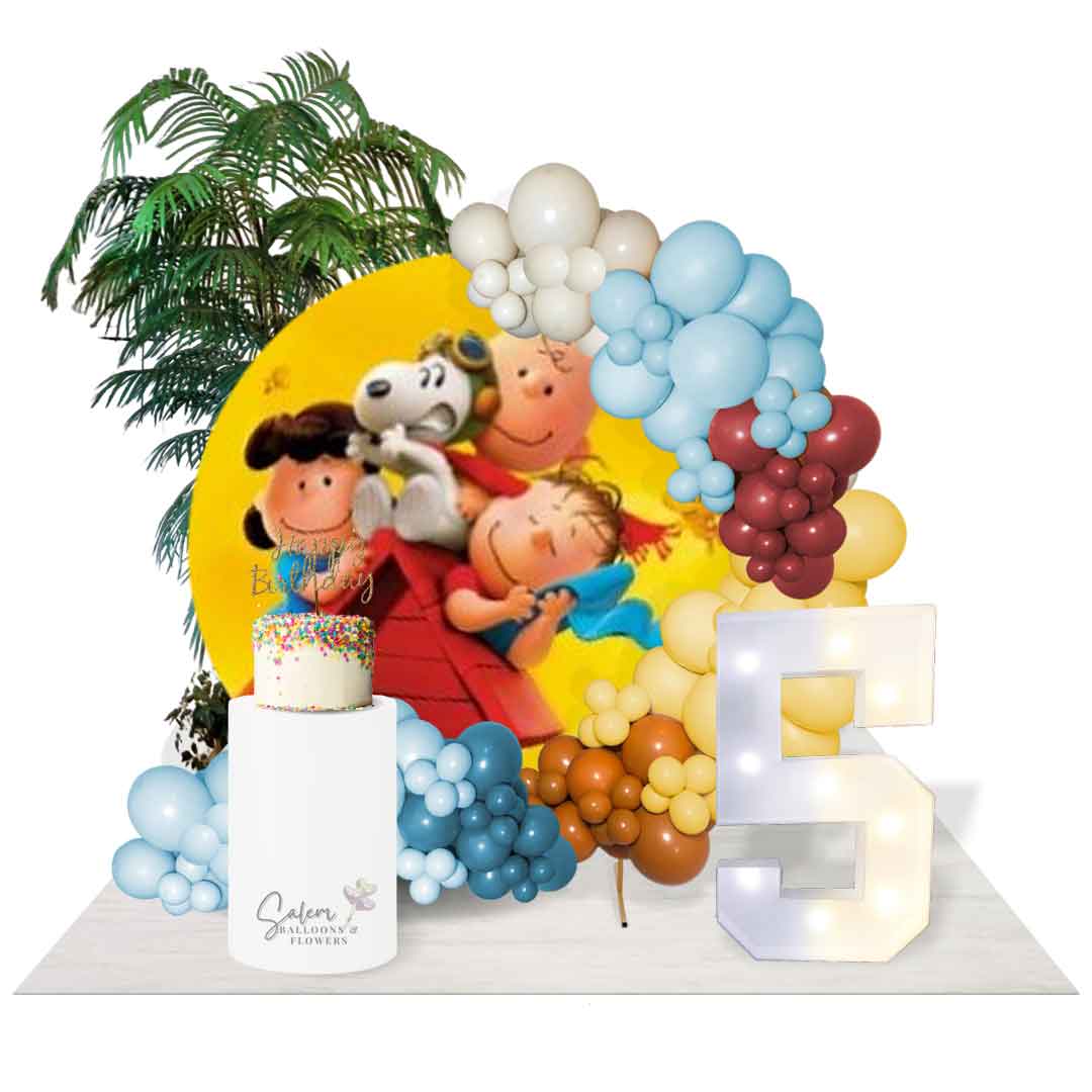Balloon garland on a hoop frame with a Charlie Brown and Snoopy backdrop. Decorated with light up marquee numbers, cake pedestal and plants. Salem Oregon Balloon decor. Balloon decorations